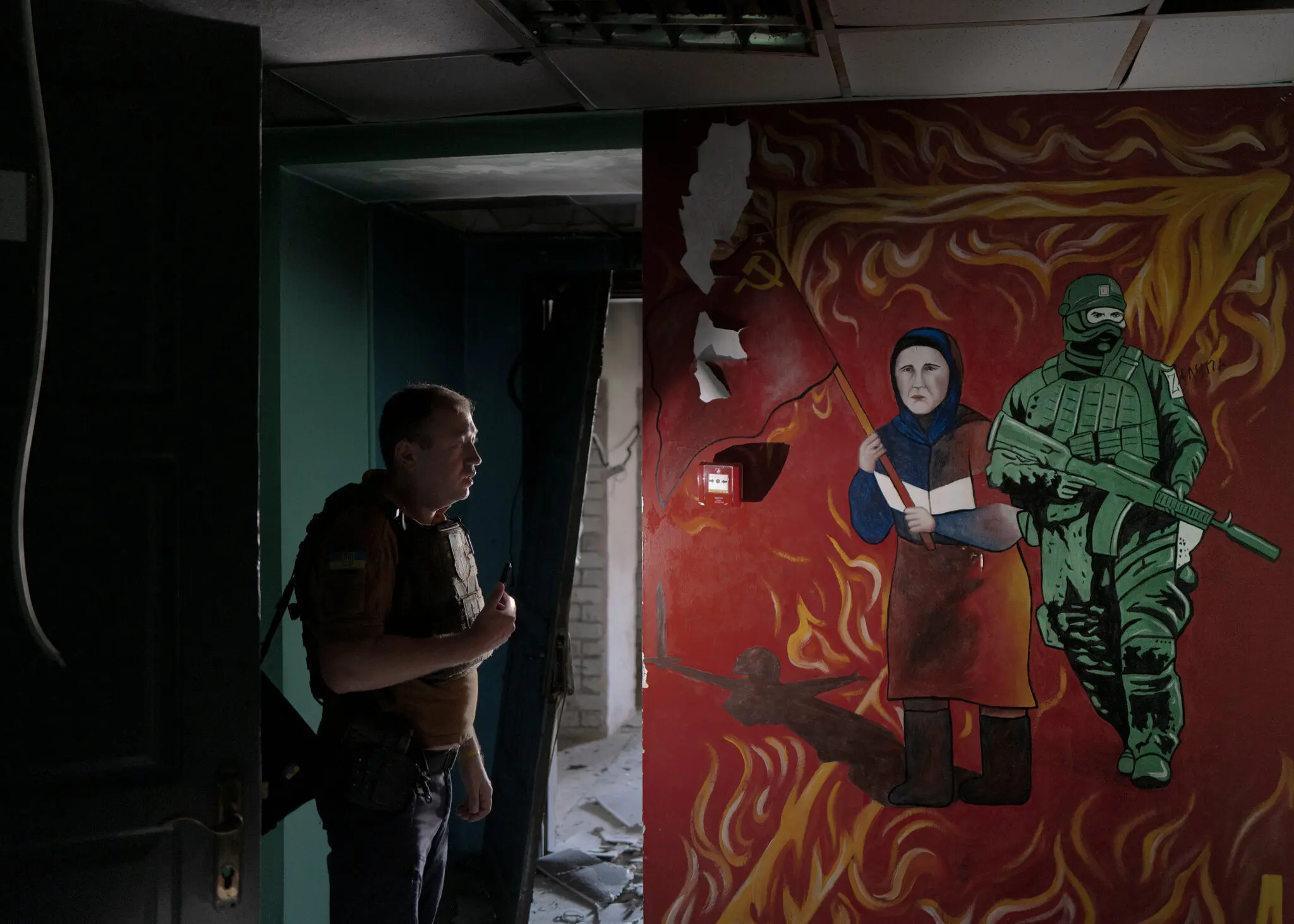 Місцевий прокурор Едуард Миргородський у колишньому відділенні міліції, яке, за його словами, використовувалося як центр тортур. На фресці неподалік зображено палаючу літеру «Z», яка стала символом росіян, які підтримують війну.